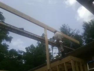 Carpenter setting a ridge beam over a new addition frame — Ice Dam Removal by Roofing Brothers in Gordon