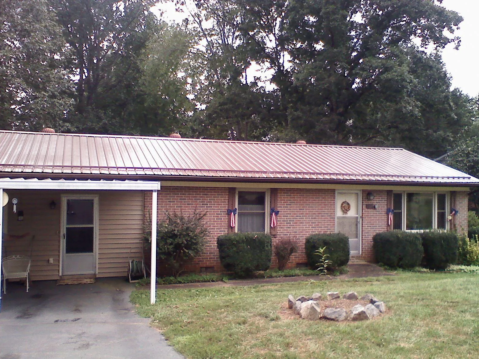 Bronze metal roof and carport on a brick ranch home — Roof Repair work by our crew in Gordon
