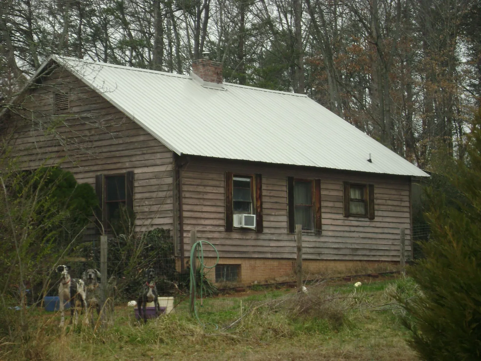 White metal roof on an old wood sided farmhouse, from a Metal Roof Installation job in Gordon